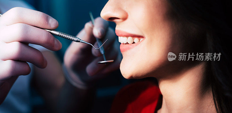 一张由专业牙医在牙科器械的帮助下检查结果一段时间后做出的美丽微笑的照片。