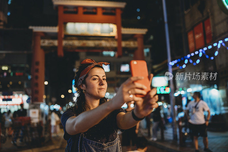 一名年轻的成年女子在香港夜市自拍