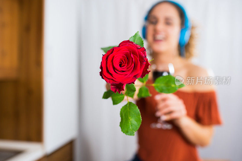 一个漂亮女人的肖像戴着耳机享受最喜欢的歌曲，而坐着喝红酒