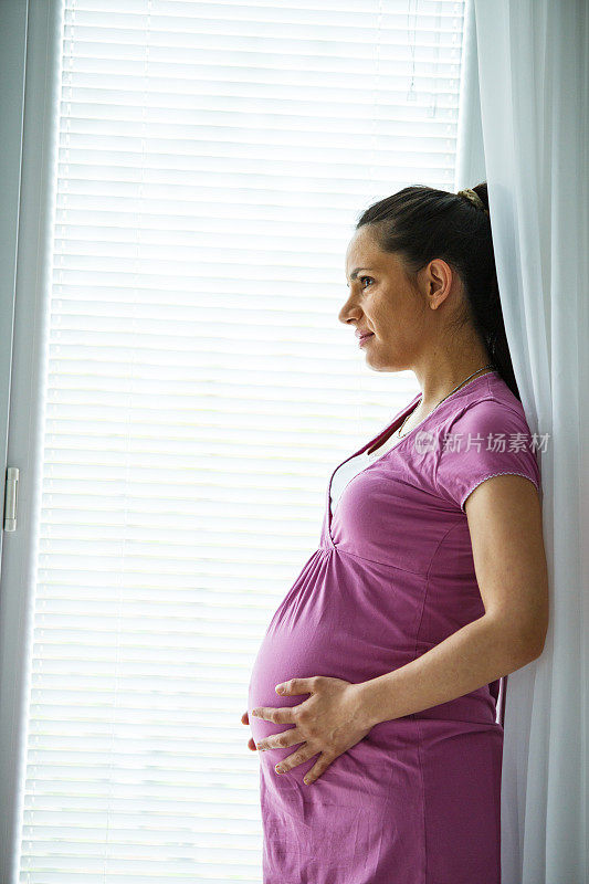 站在窗边体贴的孕妇