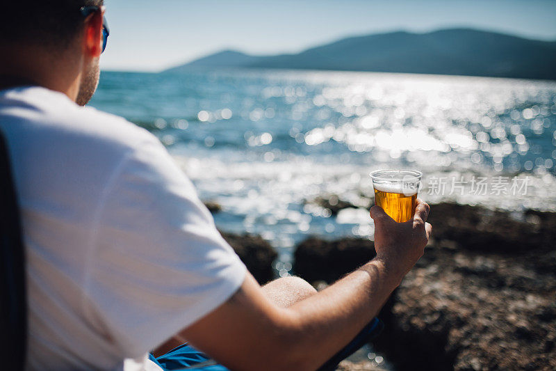 在海滩上喝啤酒的男人