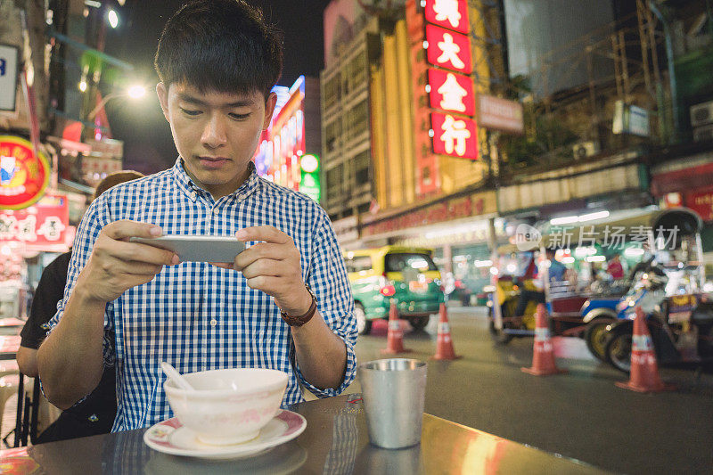 年轻的亚洲男人喜欢在泰国曼谷的中国城Yaowarat街旅游