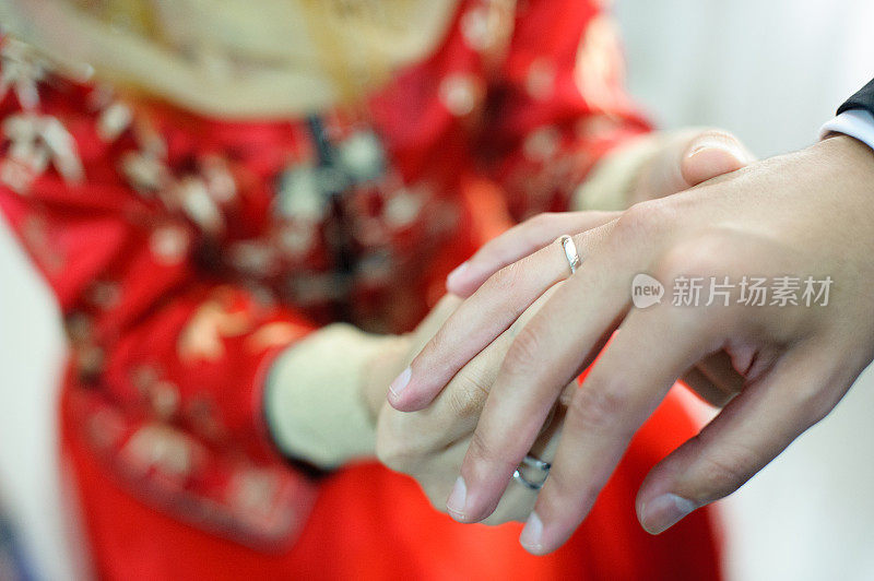 新娘把结婚戒指戴在新郎的手指上