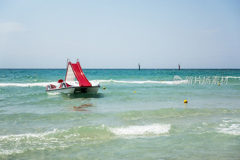希腊哈尔基迪基海滩上的一艘带滑水道的脚踏船