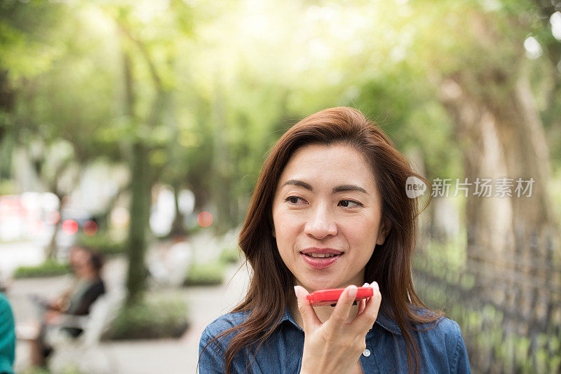 一名拿着手机的女子走在台北大街上