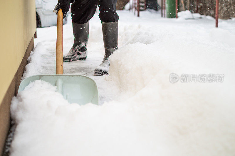 有人用雪铲清扫人行道