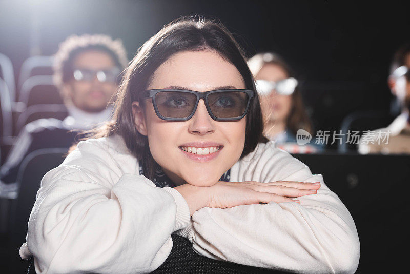 戴3d眼镜的美女在电影院看电影的选择性焦点