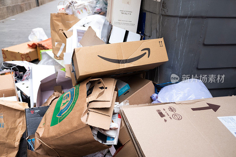 亚马逊Prime的纸板箱从一个满的垃圾桶里扔进了一堆垃圾。
