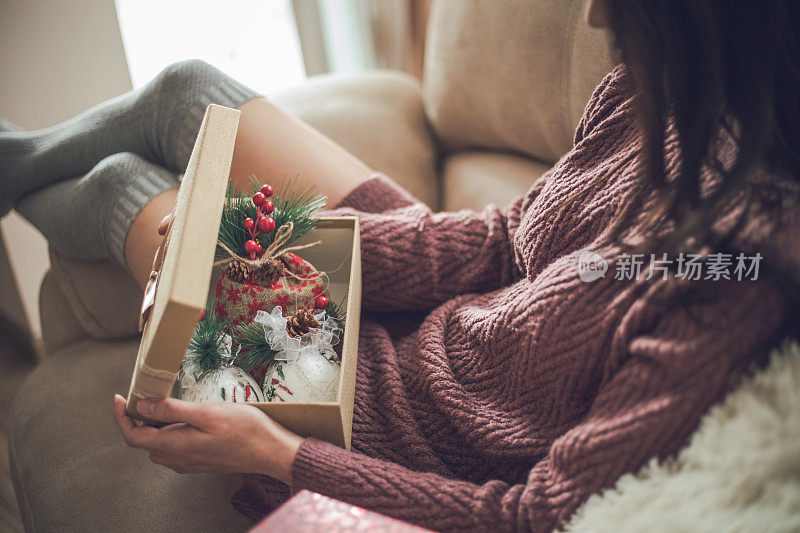 一位年轻美丽的女孩在温馨的圣诞气氛中打开了礼物