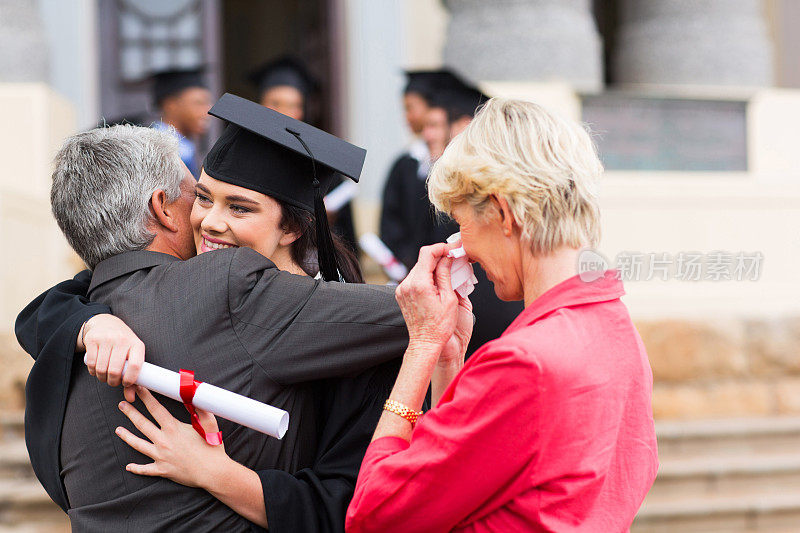 年轻的女毕业生拥抱她的父亲