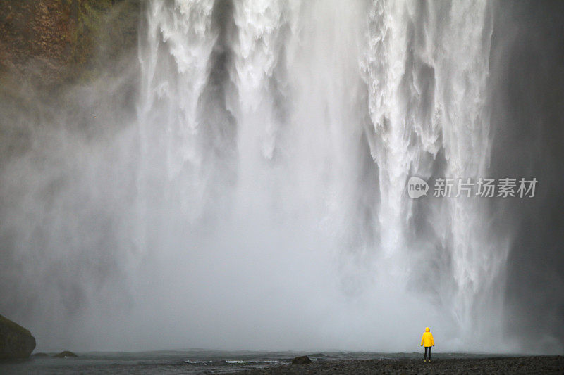 巨大的瀑布和穿着黄色夹克的人