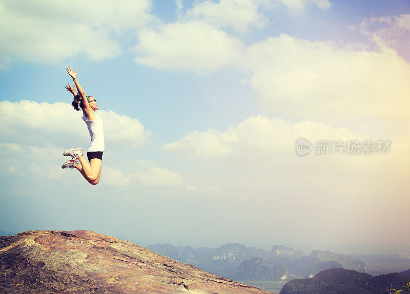 自由年轻的亚洲女人在山顶上跳