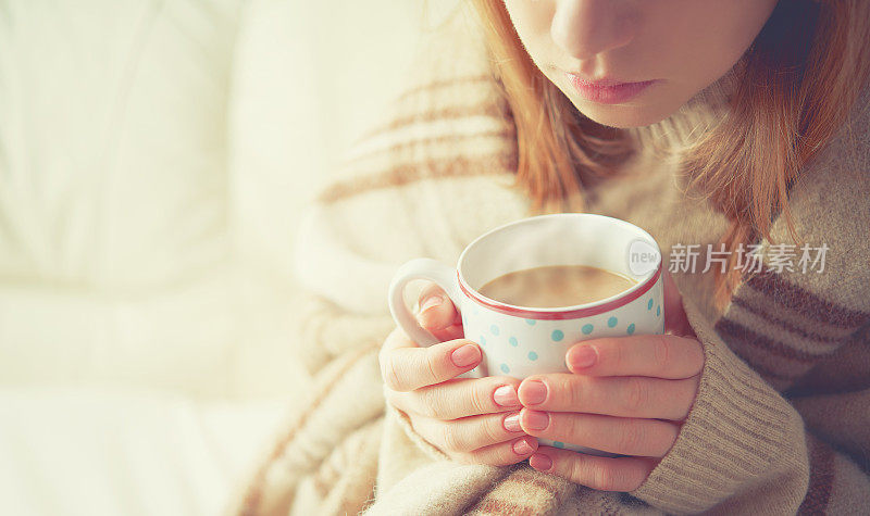 一杯热咖啡在女孩的手中暖着