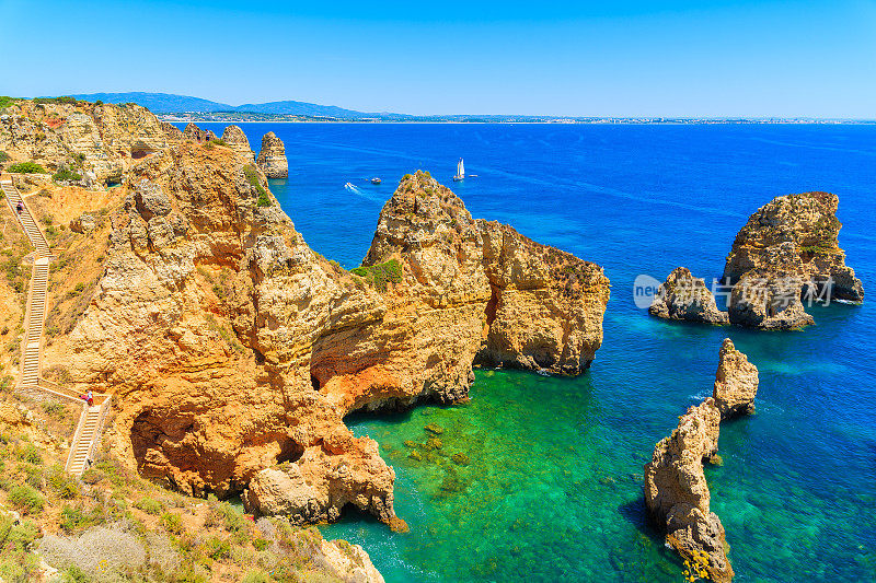 悬崖岩石和海湾碧绿的水在蓬塔达皮达德，阿尔加维地区，葡萄牙