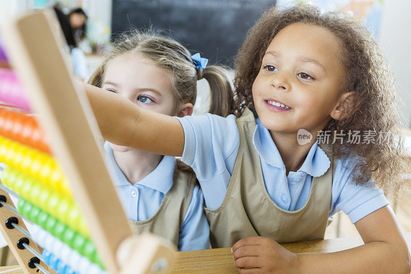 不同的幼儿园朋友在课堂上使用算盘