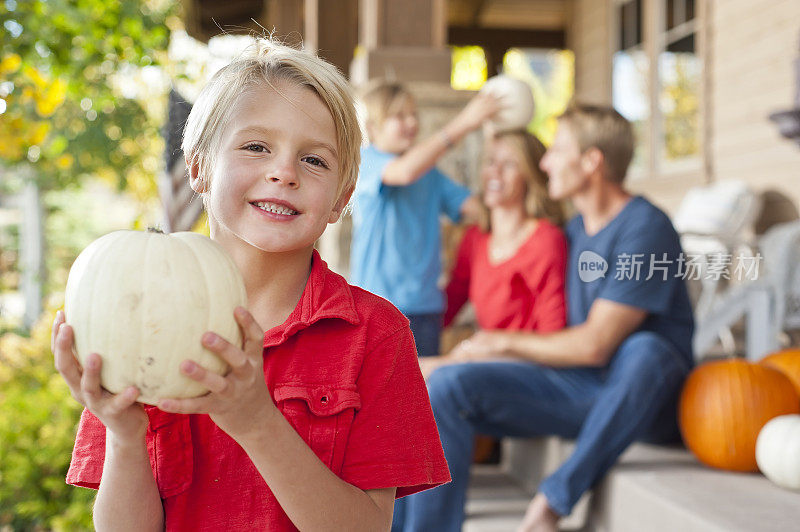 一个美国男孩和他的家人在门廊上，脸上挂着幸福的微笑