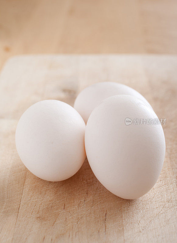 切菜板上的三个白鸡蛋