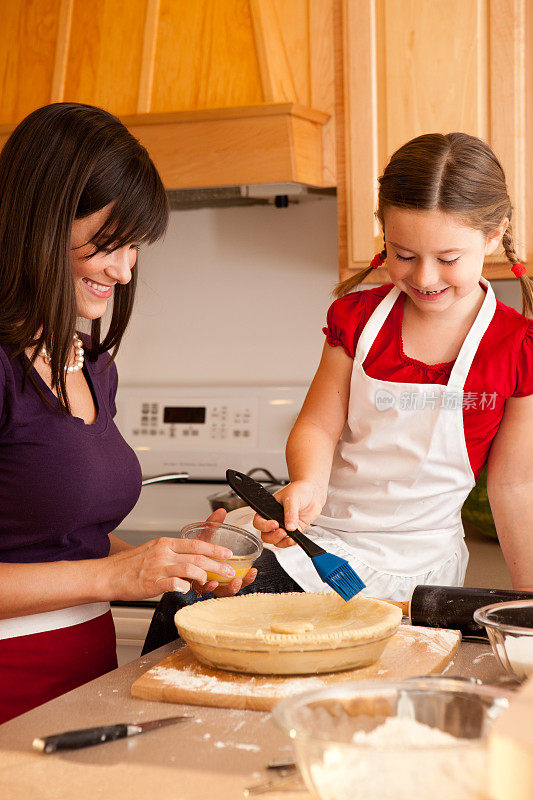 快乐的母亲和女儿在厨房做樱桃派