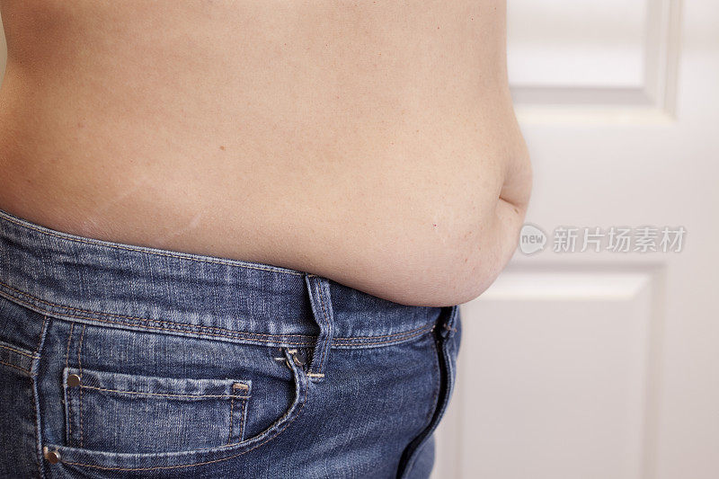 肚子挂在牛仔裤上的胖女人。