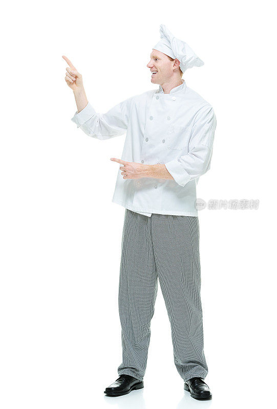 微笑的男厨师站着，指着别处