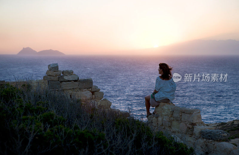 女人在前面的风景和日落在海上