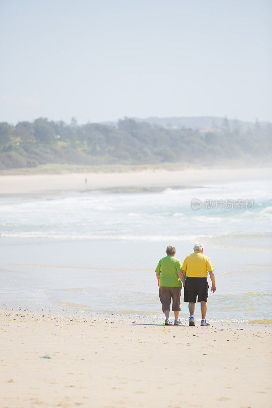 在海滩上散步的老年夫妇