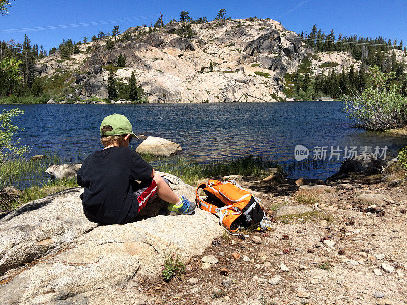 男孩在一个美丽的湖边远足休息