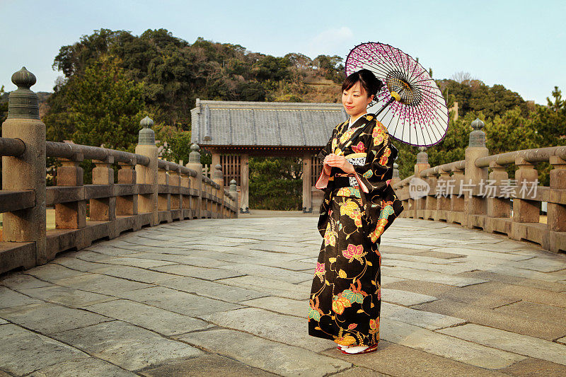 在桥上穿和服带伞的日本妇女