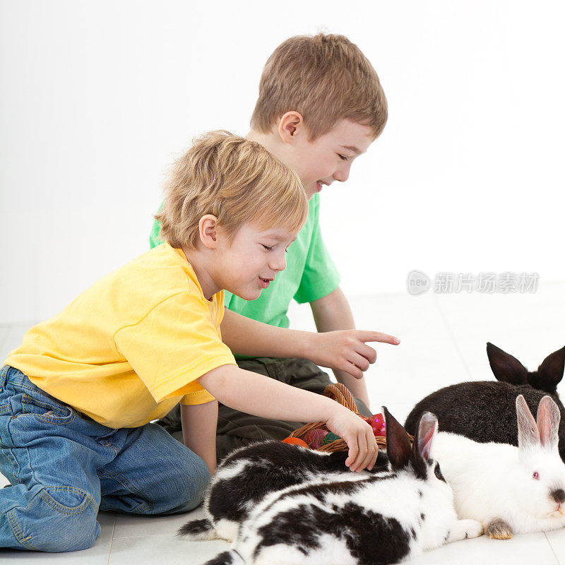 两个小男孩在玩兔子和复活节彩蛋