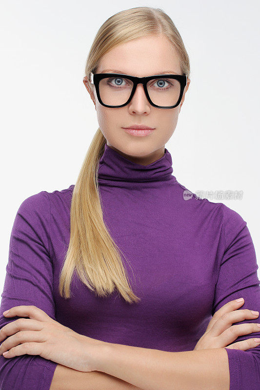 年轻女子戴着眼镜，双臂交叉站立的肖像