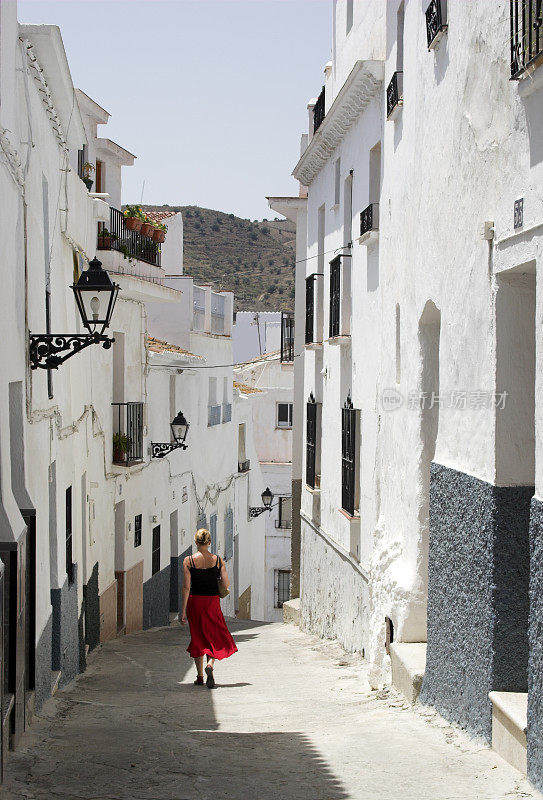一个女人穿过西班牙的村庄
