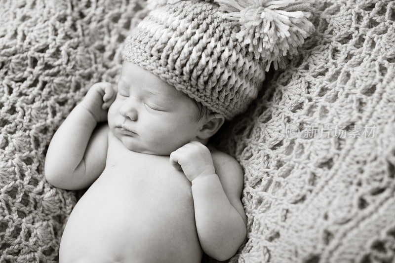新生儿戴着针织帽安静地睡觉