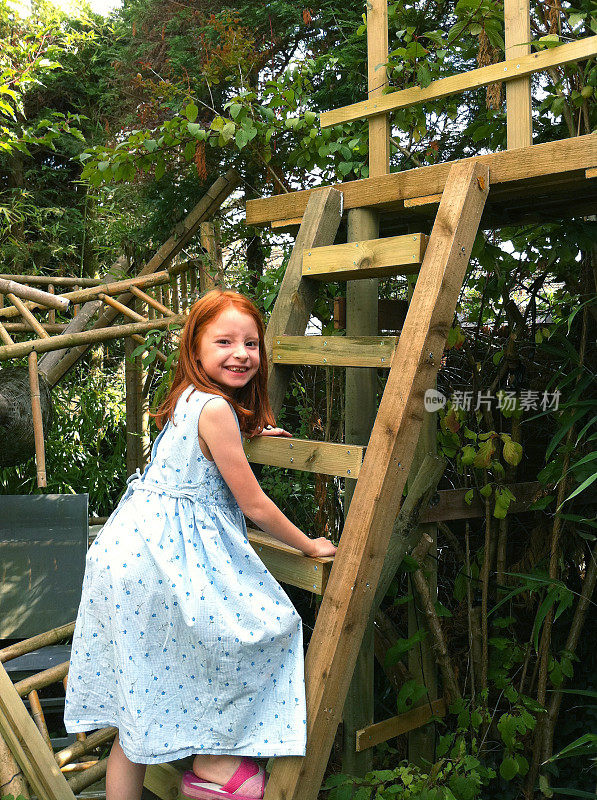 女孩爬着梯子爬到木树顶上的走道上