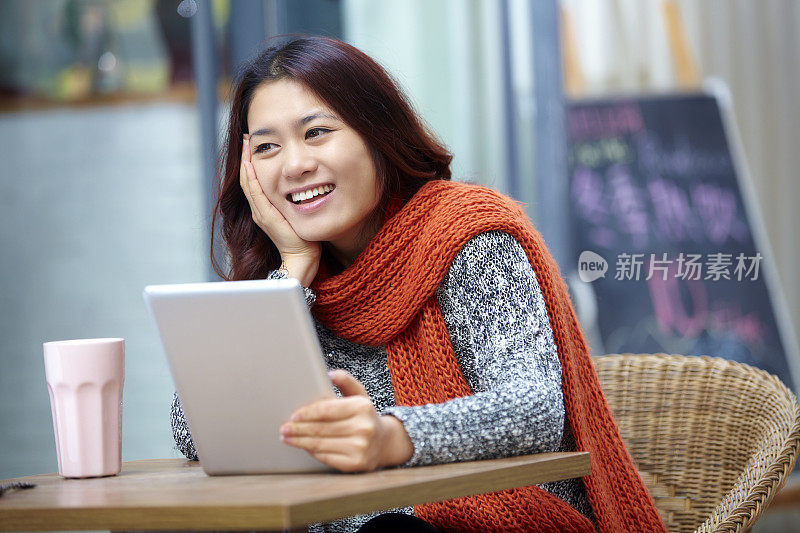 年轻美女在咖啡馆用平板电脑