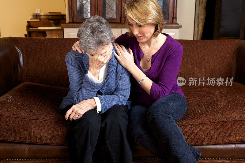 一位妇女安慰一位悲伤的年迈父母