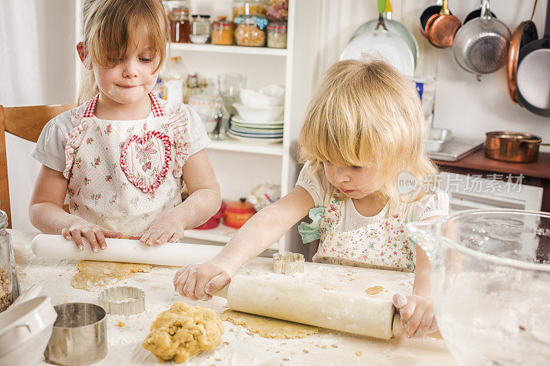 两个小女孩在厨房里准备饼干