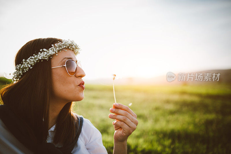 近距离的女人与太阳镜吹dadelion