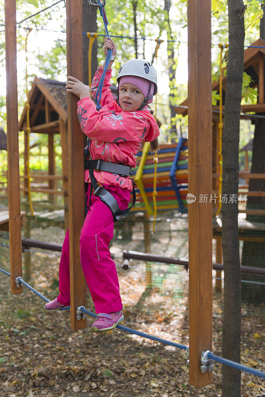 十几岁的女孩有乐趣在绳索课程冒险公园。Zipline为孩子。