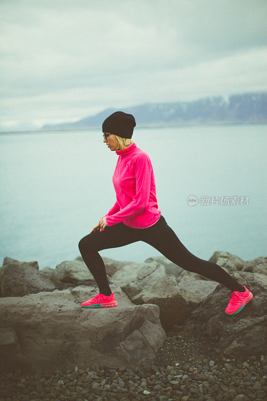 迷人而活跃的女人正在冰岛的小路上锻炼