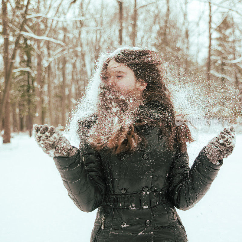 十几岁的长发女孩玩雪