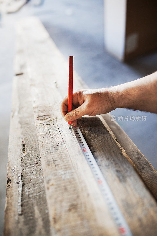 木匠在木材上测量和绘图