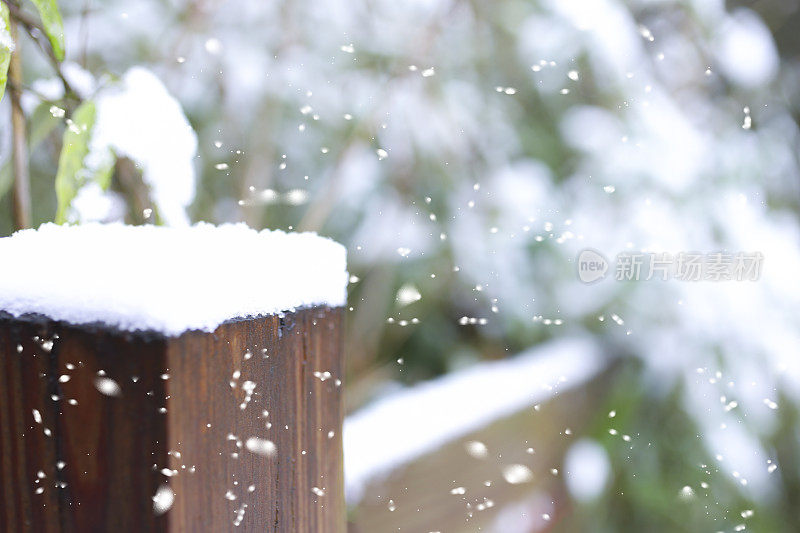 冬天的雪落在户外景观与篱笆柱。