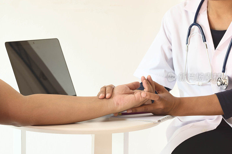 亚洲女医生将手指放在前来医院或诊所作健康检查的病人手上。