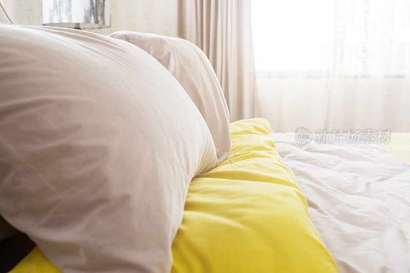 美容室的床上堆满了干净的白色枕头和床单。特写镜头。阳光下的镜头。