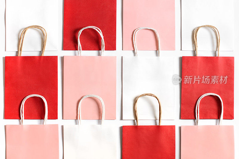红色，粉色和白色的购物袋从回收纸孤立在白色背景。作为礼物或礼物的包。