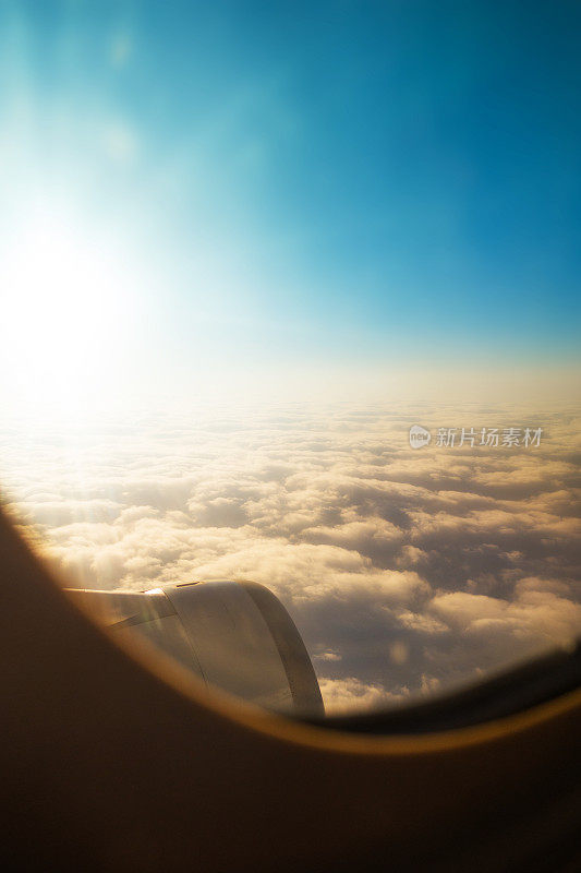 透过飞机窗口看到的云朵和天空