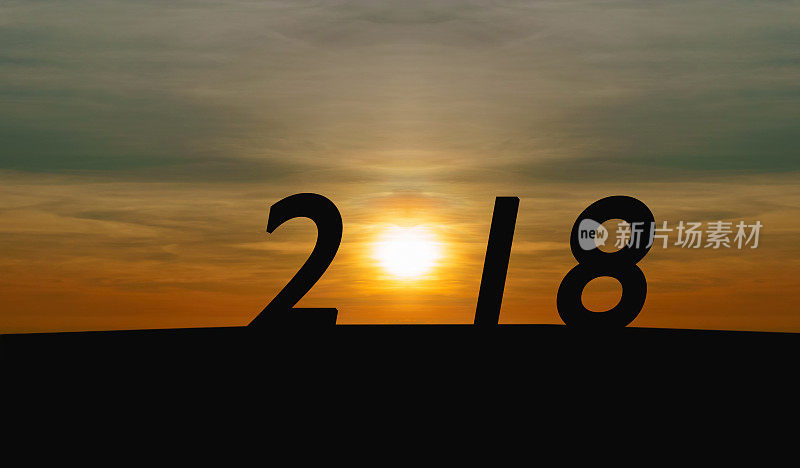 新年快乐概念。日出的剪影与字2018在山上
