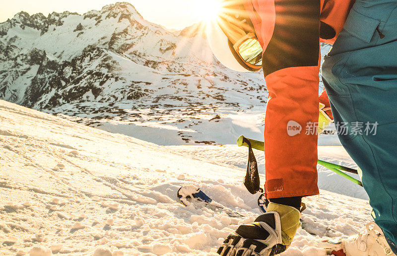 专业滑雪者在日落触摸雪在法国阿尔卑斯山滑雪胜地放松的时刻-冬季运动概念与冒险的家伙在山顶准备骑-侧面的观点与温暖的阳光滤镜