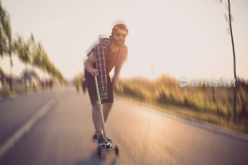 在一个阳光明媚的日子里，一个年轻人在公园里骑着滑板车