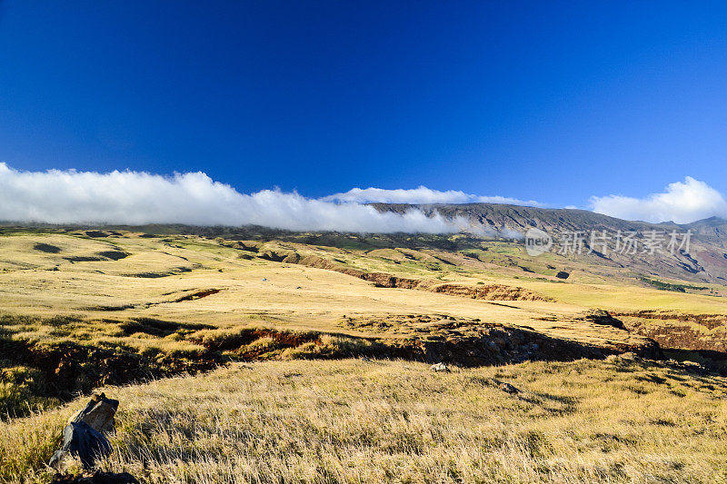 从东毛伊岛的皮拉尼高速公路南海岸看到的干草景观。山属于哈雷阿卡拉火山口，其最高峰在10027英尺。美丽的阳光和一些云-毛伊岛，夏威夷。